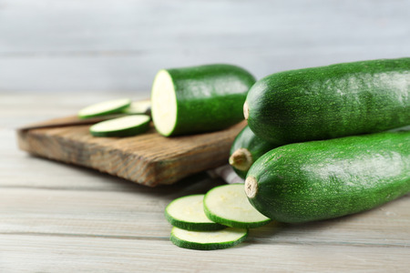 Fresh sliced zucchini on cutting board, on wooden backgroundの写真素材