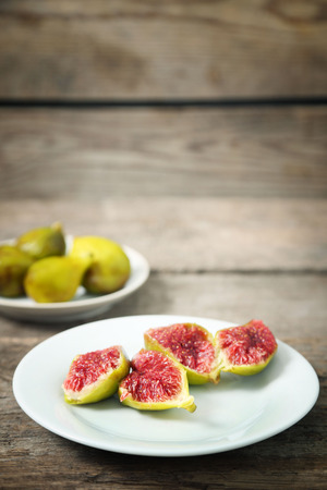 Ripe figs on plate, on wooden backgroundの写真素材