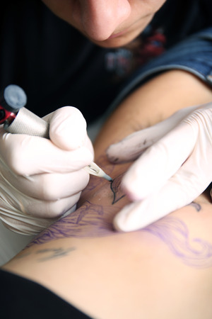 Tattooist makes tattoo, close upの写真素材