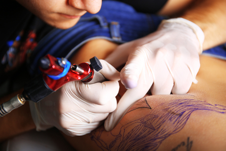 Tattooist makes tattoo, close upの写真素材