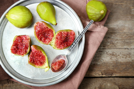 Ripe figs on tray, on wooden backgroundの写真素材