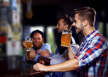 Young men drinking beer in pubの写真素材