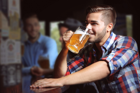 Young men drinking beer in pubの写真素材