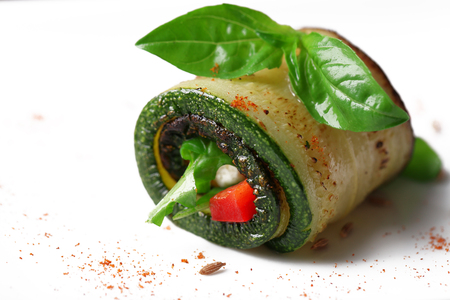 Zucchini roll with cheese, bell peppers and arugula on plate, close-upの写真素材