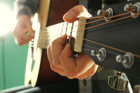 Musician plays guitar on blue background, close upの写真素材