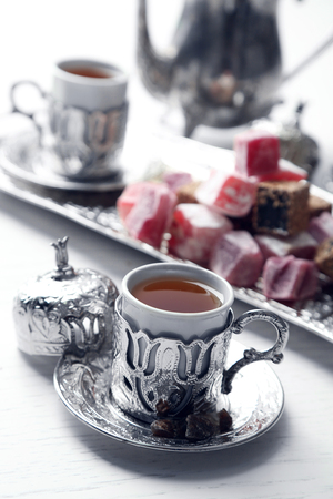 Antique tea-set with Turkish delight on table close-upの写真素材