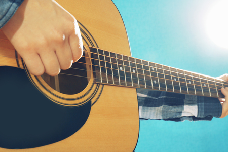 Musician plays guitar on blue background, close upの写真素材