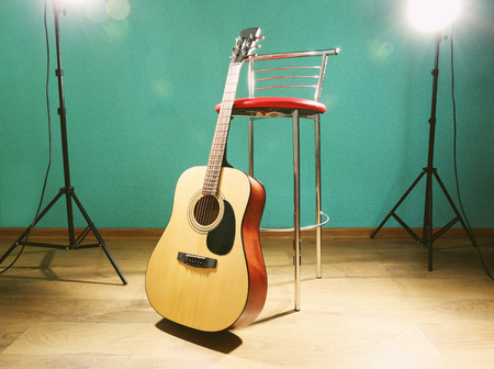 Guitar with bar stool on the floor against blue background in the studioの写真素材