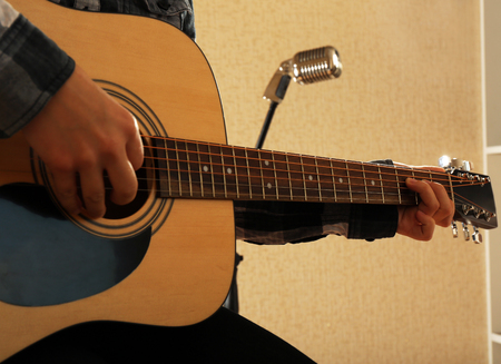 Guitarist plays guitar in the studio, close up