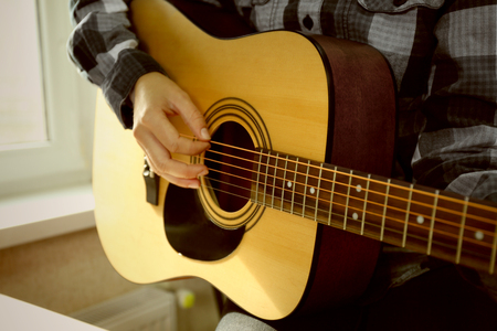 Close up view on musician playing guitars near windowの写真素材