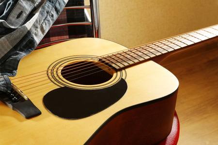 Acoustic guitar on red stool in the studio, close upの写真素材