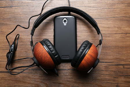 Headphones and smartphone on brown wooden backgroundの写真素材