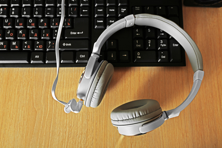 Headphones and keyboard on wooden tableの写真素材