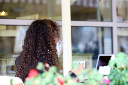 Young pretty business woman with laptop in the restaurant drinking coffeeの写真素材