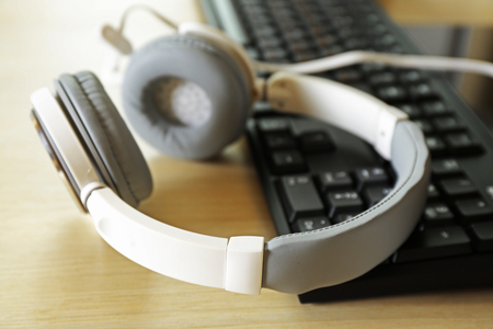 Headphones and keyboard on wooden tableの写真素材
