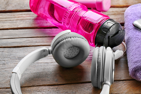 Headphones and sport equipment on old wooden backgroundの写真素材