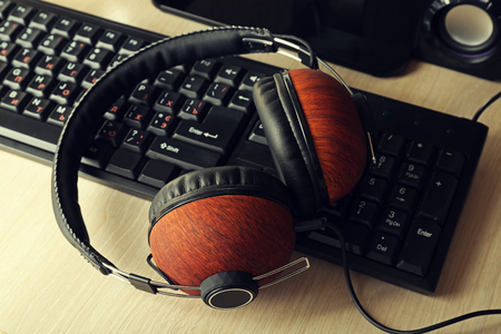 Headphones and keyboard on wooden tableの写真素材