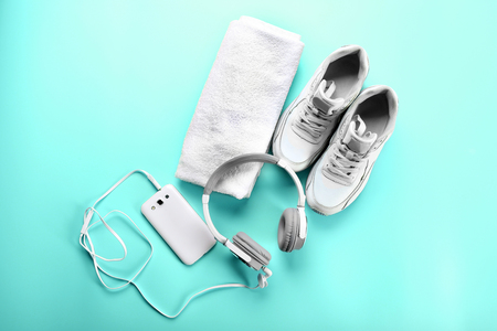 Sport shoes, towel and headphones on turquoise backgroundの写真素材