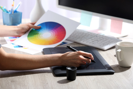 Female hand drawing on the graphic tablet in the office, close-upの写真素材