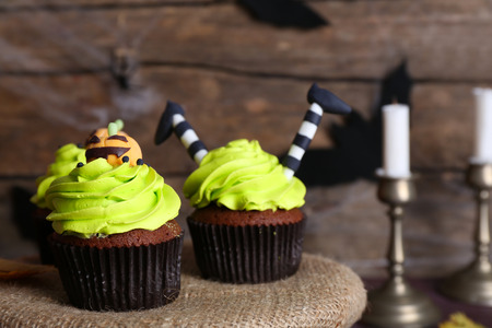 Halloween cupcakes on table on wooden wall backgroundの写真素材