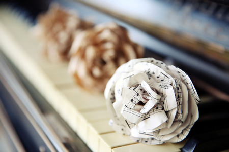 Vintage old classic piano with paper rose and musical notes on it, close upの写真素材