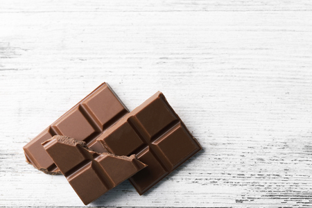 Black chocolate pieces on color wooden backgroundの写真素材