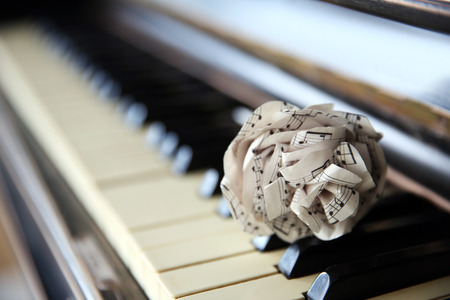 Vintage old classic piano with paper rose and musical notes on it, close upの写真素材