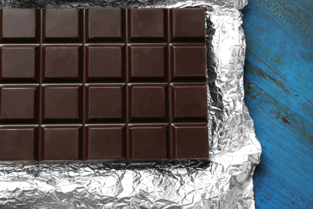 Dark Chocolate bar in foil  on gray background