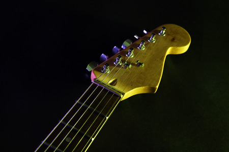 Part of electric guitar, on dark lighted backgroundの写真素材