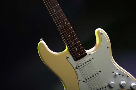 Part of electric guitar, on dark lighted backgroundの写真素材