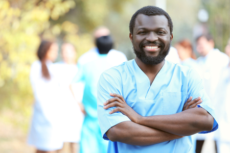 Portrait of an handsome smiling doctor on blurred backgroundの写真素材