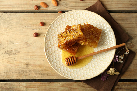 Honeycombs on plate on wooden backgroundの写真素材