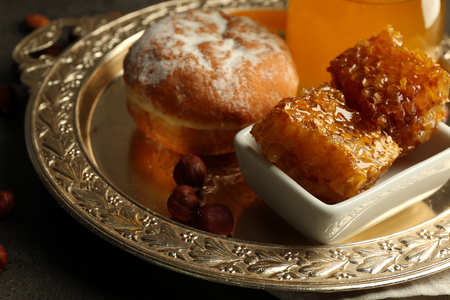 Glass jar and bowl with honey and nuts on gray backgroundの写真素材