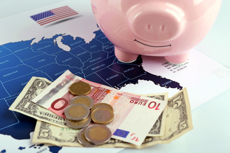 Piggy money box, banknotes and coins on the USA map background, close-upの写真素材