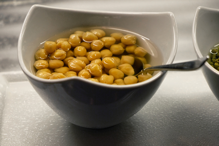 Canned corn and juice in a white bowl, on the table, close-upの写真素材