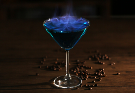 Burning cocktail and coffee beans on a tableの写真素材