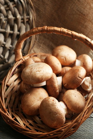 Mushrooms in basket on wooden surfaceの写真素材