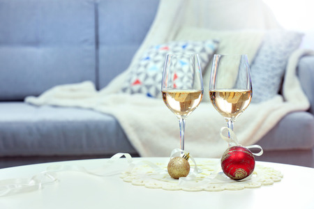 Two champagne glasses with Christmas decor on home interior backgroundの写真素材