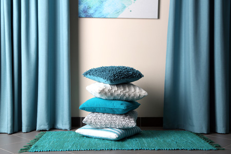 Multicoloured pillows on a carpet in a roomの写真素材