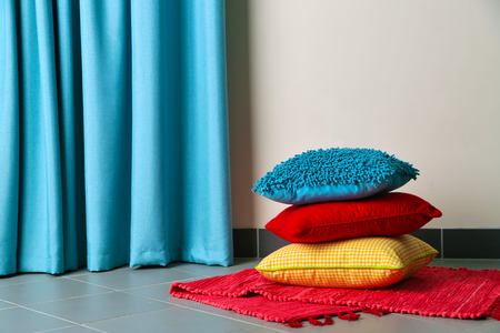 Multicoloured pillows on a carpet in a roomの写真素材