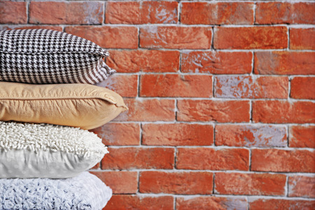 Multicoloured pillows on a brick wall backgroundの写真素材