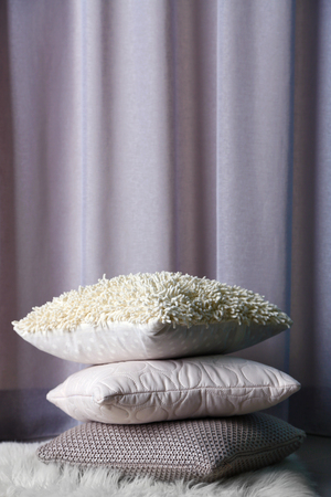 Multicoloured pillows on a carpet in a roomの写真素材