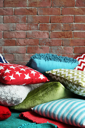 Multicoloured pillows on a brick wall backgroundの写真素材