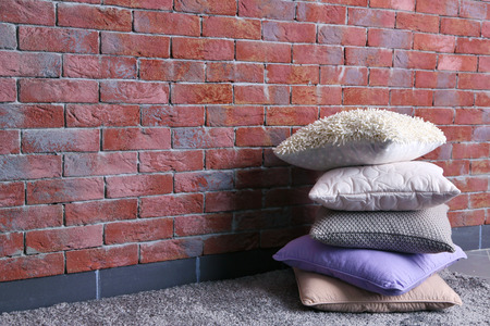 Multicoloured pillows on a brick wall backgroundの写真素材
