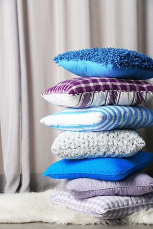 Multicoloured pillows on a carpet in a roomの写真素材