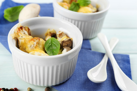 French dish julienne. Mushroom, chicken and cheese gratin in ceramic bowls, on wooden backgroundの写真素材