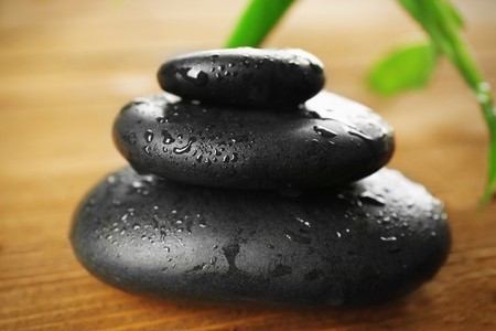 Spa stones and bamboo branch on wooden backgroundの写真素材