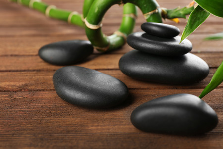 Spa stones and bamboo branch on wooden backgroundの写真素材