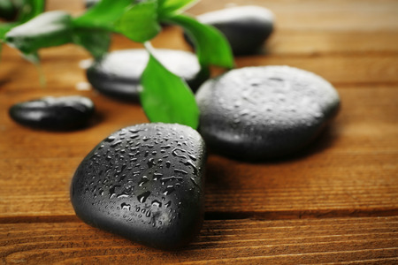 Spa stones and bamboo branch on wooden backgroundの写真素材