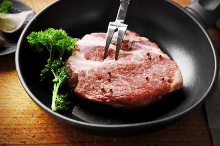 Marbled beef steak on pan and spices on wooden backgroundの写真素材